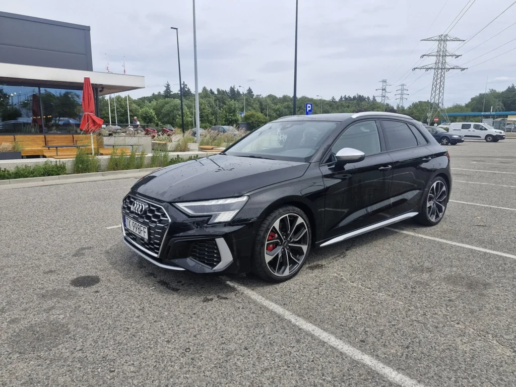 Audi S3 2024 czarne – sportowy samochód hatchback z aluminiowymi felgami i agresywnym grillem, widok przód z boku