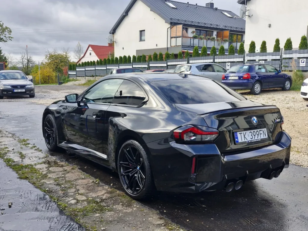 BMW M2 2024 czarne – widok z tyłu z boku, sportowe coupe premium dostępne w wynajmie długoterminowym APKARS