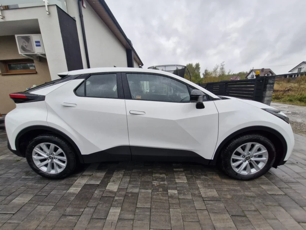 Nowa Toyota C-HR 2025 biała – widok boczny SUV-a coupe, dynamiczna linia nadwozia