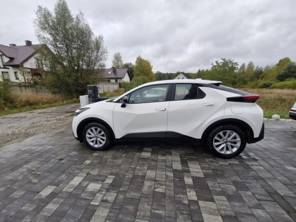 Nowa Toyota C-HR 2025 biała – widok z boku, kompaktowy SUV coupe dostępny w wynajmie długoterminowym APKARS