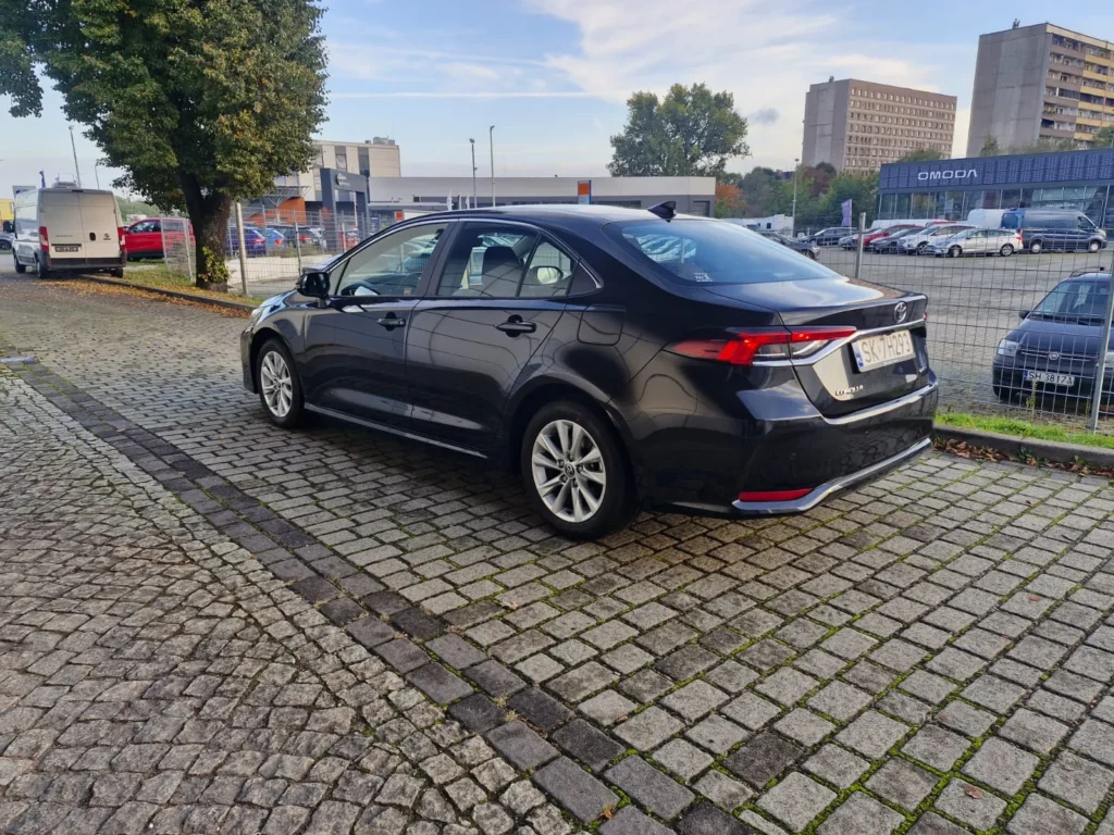 Toyota Corolla czarna sedan – widok boczny z tyłu, oferta wynajmu APKARS