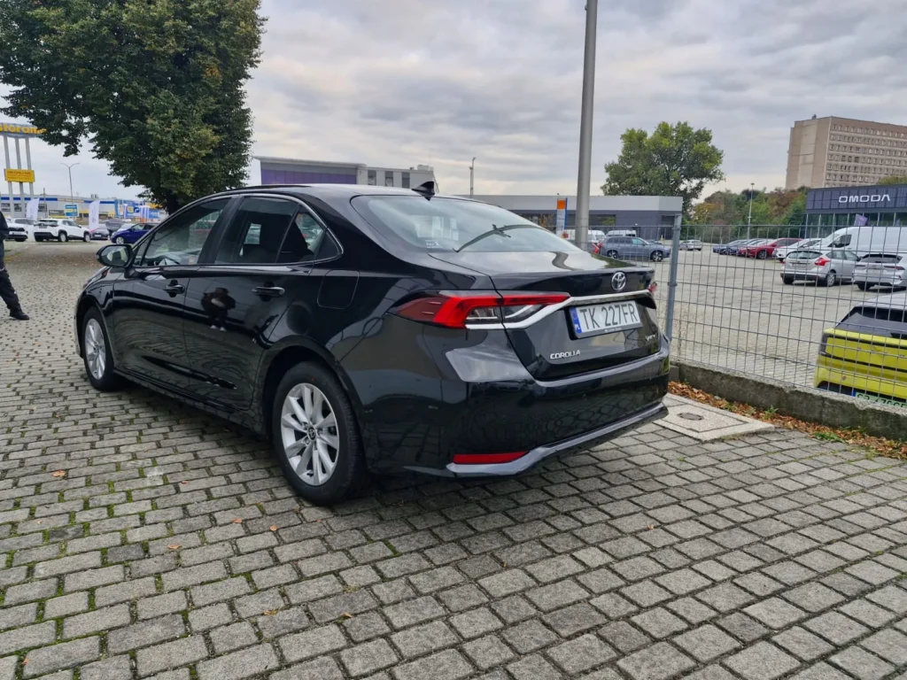 Toyota Corolla czarna sedan – widok tylnego boku, dynamiczna linia nadwozia i LED-owe światła