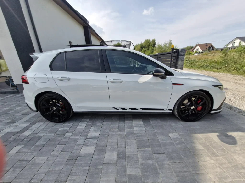 Volkswagen Golf GTI Clubsport 2023 biały – widok z boku, sportowe felgi i czerwone zaciski hamulcowe