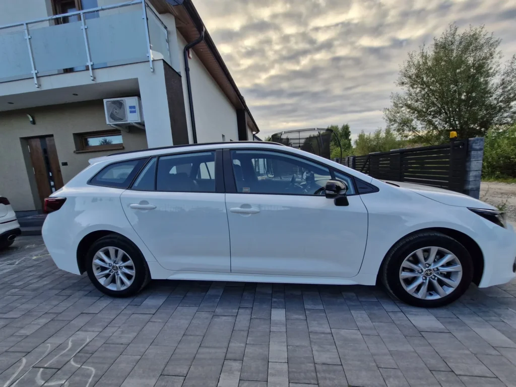 Toyota Corolla 2025 biała kombi – widok z boku, ekonomiczny samochód idealny dla firm i rodzin